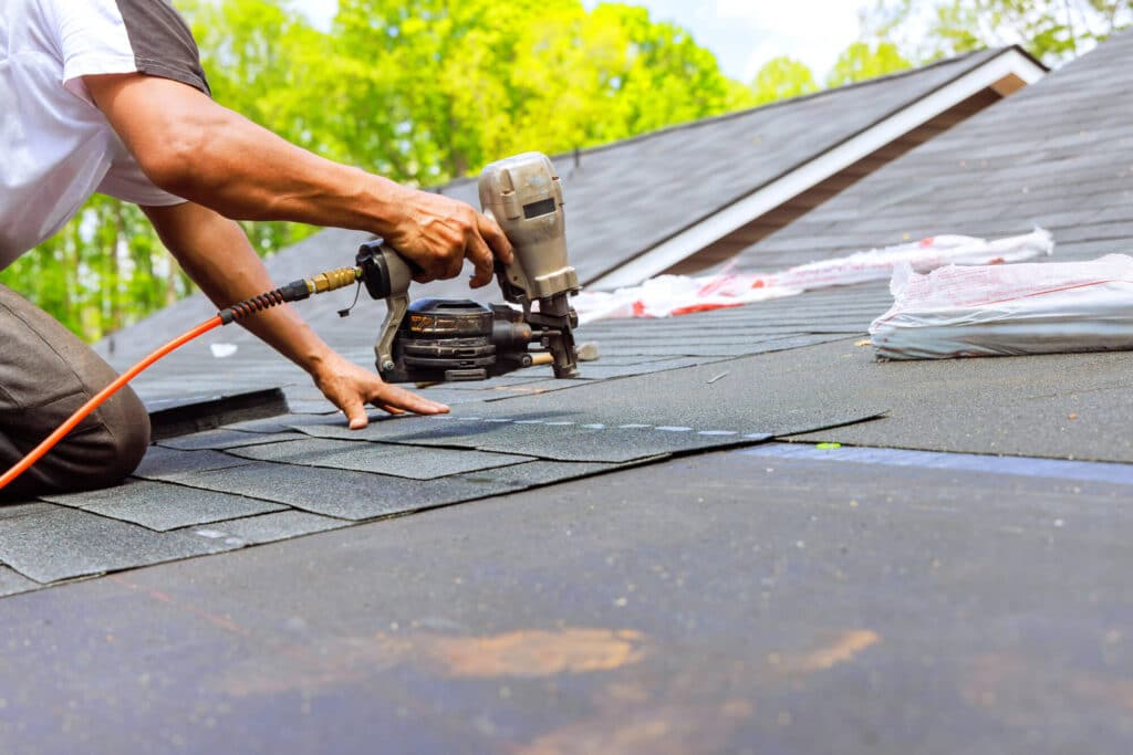 Roofer installing asphalt shingles